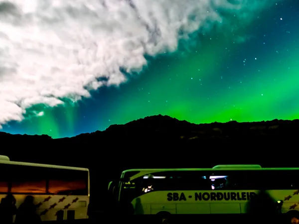 Green Northern Lights over a road outside Reykjavik
