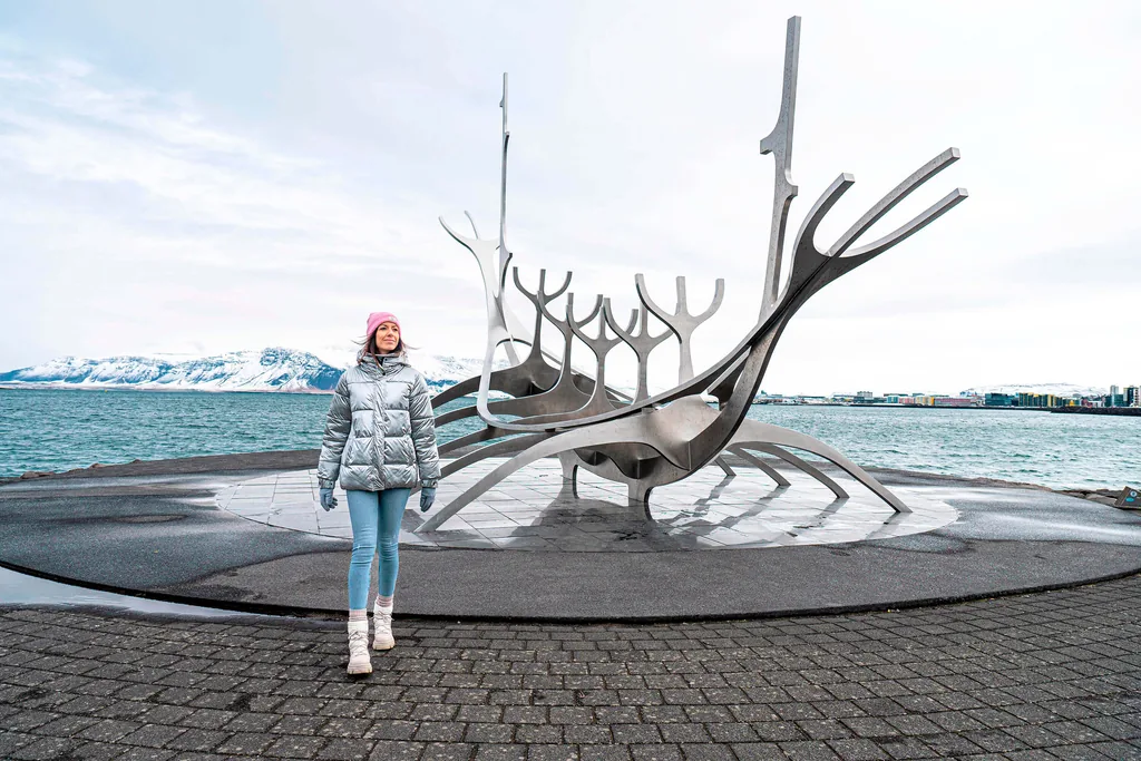 A visitor walking past the Sun Voyager sculpture on the Sæbraut waterfront in winter