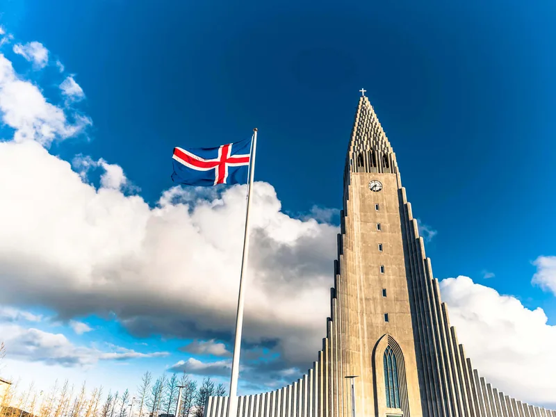 Hallgrímskirkja church seen from below with the Icelandic flag flying